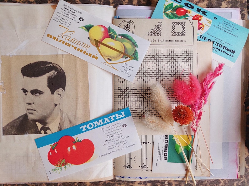 May include: A vintage scrapbook page with a black and white portrait, colorful product labels, and dried flowers. The labels feature illustrations of apples and tomatoes, with text in Cyrillic script.