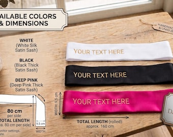 May include: Three satin sashes in white, black, and deep pink, each featuring the gold text 'YOUR TEXT HERE'. The sashes measure 9.5 cm in width and 160 cm in total length. The image includes labels for colors, dimensions, and a brand logo.