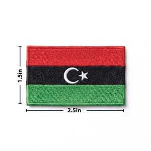 K&ouml;nnte beinhalten: Ein rechteckiger, gestickter Aufn&auml;her mit der libyschen Flagge. Der Aufn&auml;her ist 6,35 cm breit und 3,81 cm hoch. Das Flaggen-Design umfasst einen roten oberen Streifen, einen schwarzen mittleren Streifen mit wei&szlig;em Halbmond und Stern sowie einen gr&uuml;nen unteren Streifen.