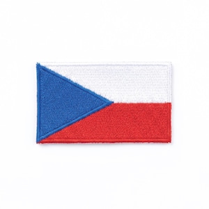Puede incluir: Parche bordado con la bandera de la República Checa. El parche rectangular muestra el diseño de la bandera: un triángulo azul a la izquierda, blanco arriba y rojo abajo. El parche es probablemente para ropa o accesorios.