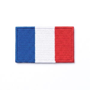 May include: A rectangular embroidered patch featuring the French national flag design. The patch displays three vertical stripes of equal width in blue, white, and red, with a stitched border surrounding the entire rectangular shape.