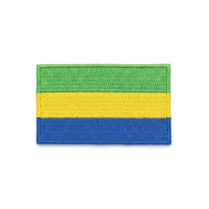 Puede incluir: Parche bordado con la bandera de Gabón. El parche rectangular tiene tres franjas horizontales: verde en la parte superior, amarilla en el medio y azul en la parte inferior. El parche está hecho de tela con apariencia texturizada.