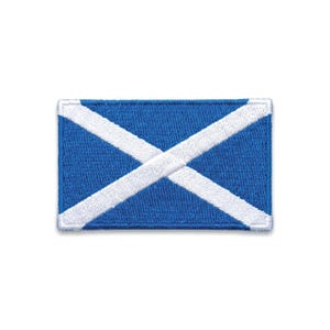 Op de afbeelding: Een rechthoekige patch met de Schotse vlag, de Saltire, met een blauwe achtergrond en een witte diagonale kruis. De randen zijn afgewerkt met witte stiksels. Een symbool van Schotse identiteit en erfgoed.
