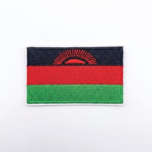 Op de afbeelding: Geborduurde patch met de vlag van Malawi. De rechthoekige patch heeft een zwarte bovenste streep, een rode middelste streep en een groene onderste streep. Een rode zon komt op vanaf de bovenkant van de rode streep.