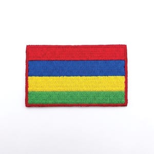 May include: Embroidered patch featuring a rectangular design with horizontal stripes. The top stripe is red, followed by blue, yellow, and green stripes. The patch has a red border and is set against a white background.