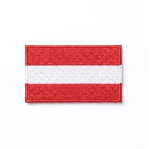 Op de afbeelding: Geborduurde rechthoekige patch met de vlag van Oostenrijk. De patch heeft een rode achtergrond met een horizontale witte streep in het midden. Geschikt voor kleding of accessoires.