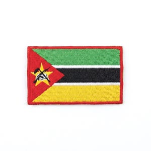 Può includere: Toppa ricamata raffigurante la bandiera del Mozambico. La toppa rettangolare ha un bordo rosso e mostra il disegno della bandiera: strisce verdi, nere, gialle, un triangolo rosso con una stella e attrezzi incrociati.