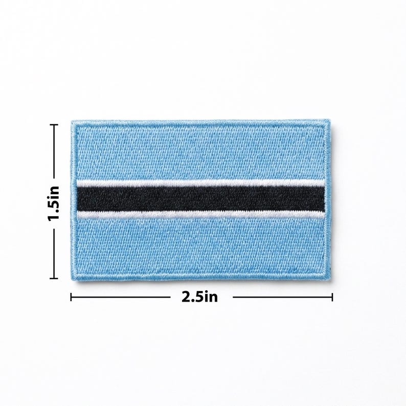 May include: A rectangular patch featuring the flag of Botswana. The patch is light blue with a black stripe in the center, bordered by a white stripe. The patch measures 2.5 inches wide and 1.5 inches high.