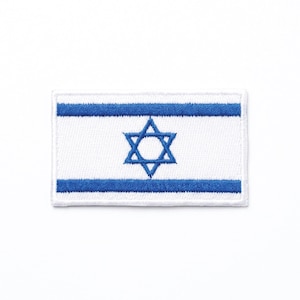 May include: Embroidered patch depicting the flag of Israel. The design features a white background, two horizontal blue stripes, and a blue Star of David in the centre. The patch is rectangular in shape.