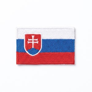Könnte beinhalten: Gestickter Aufnäher mit der Flagge der Slowakei. Der rechteckige Aufnäher hat horizontale Streifen in Weiß, Blau und Rot. Auf der linken Seite befindet sich ein Wappen mit einem weißen Doppelkreuz auf blauem Grund.