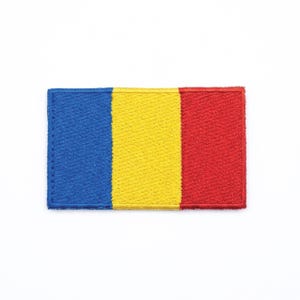 May include: Embroidered patch featuring the flag of Romania. The rectangular patch displays vertical stripes of blue, yellow, and red. The patch is set against a white background.