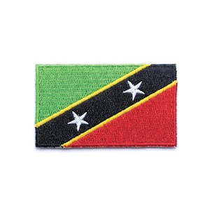 Op de afbeelding: Geborduurde patch met de vlag van Saint Kitts en Nevis. De rechthoekige patch heeft een groen linkerbovendeel, een rood rechteronderdeel en een zwarte diagonale streep met twee witte sterren. Een gele streep begrenst de zwarte streep.