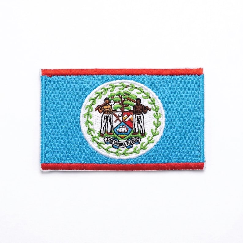 Pu&ograve; includere: Toppa ricamata raffigurante la bandiera del Belize. La toppa ha uno sfondo azzurro con un bordo rosso. Il centro presenta un cerchio bianco con lo stemma del Belize, che include due figure, un albero e la scritta "SUB UMBRA FLOREO".