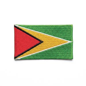 Puede incluir: Parche bordado con la bandera de Guyana. El diseño incluye un triángulo rojo con borde negro, una flecha amarilla y un fondo verde. El parche es rectangular y tiene un borde blanco.