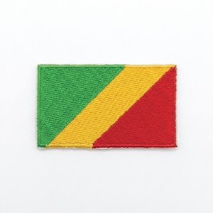 May include: Embroidered patch featuring the flag of the Republic of the Congo. The rectangular patch has a green upper left corner, a yellow diagonal stripe, and a red lower right corner. The patch is on a white background.