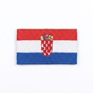 Puede incluir: Parche bordado con la bandera de Croacia. El parche rectangular tiene franjas horizontales rojas, blancas y azules. El escudo de armas croata está centrado, un escudo ajedrezado rojo y blanco coronado por una corona.