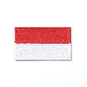 May include: Embroidered patch featuring the flag of Indonesia. The rectangular patch has a red upper half and a white lower half. The edges are neatly stitched with a white border, creating a clean and defined look. The patch is designed for application on clothing or accessories.