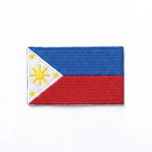 Op de afbeelding: Geborduurde patch met de vlag van de Filipijnen. De rechthoekige patch heeft een blauwe bovenkant, een rode onderkant en een witte driehoek aan de linkerkant. De driehoek bevat een gele zon en drie gele sterren.