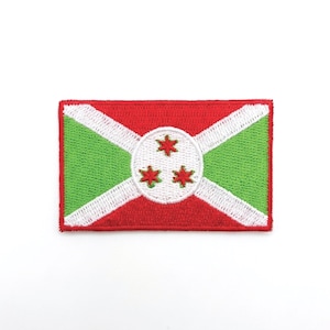 May include: Embroidered patch depicting the flag of Burundi. The rectangular patch has a red background with green diagonal stripes and a white circle in the centre. Three red stars are inside the circle.