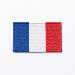 Può includere: Toppa ricamata con la bandiera francese. La toppa rettangolare presenta strisce verticali blu, bianche e rosse. I bordi sono ben cuciti e i colori sono vivaci su uno sfondo bianco.