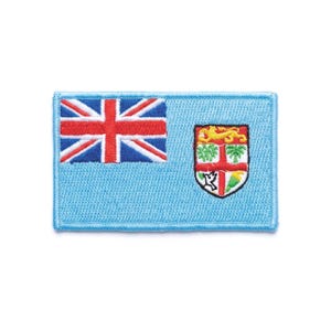 May include: A rectangular patch featuring the flag of Fiji. The upper left corner displays the Union Jack, with the Fijian coat of arms on the right. The patch has a light blue background and a stitched border.