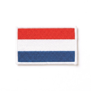 Puede incluir: Parche rectangular bordado con la bandera de los Países Bajos. El diseño presenta tres franjas horizontales: roja, blanca y azul. El parche está bordeado con costuras blancas, creando un borde limpio alrededor de la bandera.