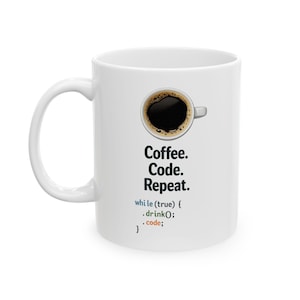May include: White ceramic coffee mug with a black coffee design and the text "Coffee. Code. Repeat." The mug also features a code snippet: "while (true) { .drink(); .code; }."