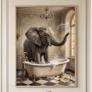 May include: A framed wall art print depicting a grey elephant standing inside a white clawfoot bathtub in a bathroom. The elephant sprays water from its trunk, while a gold faucet and a crystal chandelier are visible in the room with tiled floors.