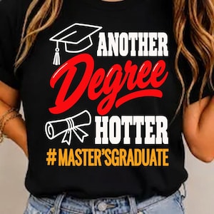 Può includere: Una t-shirt nera con un'icona bianca di un tocco di laurea, il testo rosso "ANOTHER Degree", il testo bianco "HOTTER" e l'hashtag giallo "#MASTER'SGRADUATE" con un grafico di un diploma bianco sotto la parola Degree.