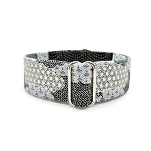 May include: A black and white patterned dog collar with a silver buckle. The pattern features geometric shapes and a wave design.