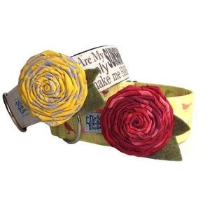 May include: Two fabric dog collars with a floral design. The collars are made of a white fabric with a yellow and red floral pattern. The text "Are My Sunny Days Only Me Happy" is printed on the collar.