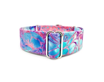 May include: A vibrant dog collar featuring a floral pattern in shades of blue, pink, and purple. The collar has a silver-colored metal buckle and is set against a white background. The fabric design resembles a watercolor painting.