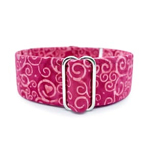 May include: A pink dog collar with a white swirl pattern and a silver buckle.