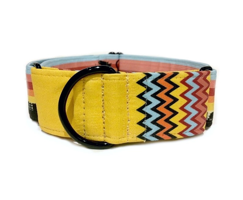 May include: Yellow dog collar with a black metal D-ring and a colorful chevron pattern.