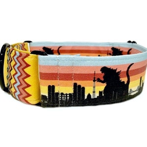 May include: A yellow, red, and blue striped dog collar with a black silhouette of Godzilla destroying a city skyline.