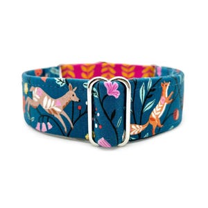 May include: A teal fabric pet collar featuring a repeating pattern of brown deer and orange foxes among pink flowers and black leafy branches. The collar includes a silver metal rectangular slider and a bright pink inner lining with a yellow leaf print.