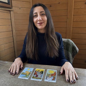 May include: Three tarot cards laid out on a wooden surface. The cards are titled The Star, The Empress, and The Sun. Each card features colourful illustrations with detailed imagery, including a figure by water, a seated queen, and a child on a horse.