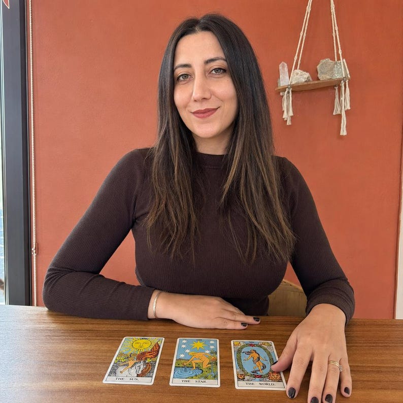 May include: Three tarot cards laid out on a wooden surface, featuring The Sun, The Star, and The World. Each card displays colorful illustrations with distinct imagery and text labels at the bottom, representing classic tarot deck iconography.