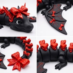 May include: A matte black articulated dragon figurine featuring glossy red bows on its head, wings, and along its segmented tail. The dragon has large black eyes and a smooth finish, with intricate red line details etched onto the surface of its wings.