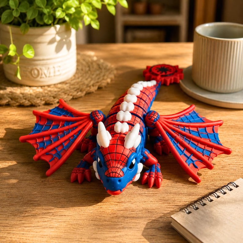 May include: A articulated dragon figure featuring a red and blue color scheme with a web-like pattern across its head and wings. The creature has white horns and a white spine, with a red circular gear-like detail at the end of its long tail.