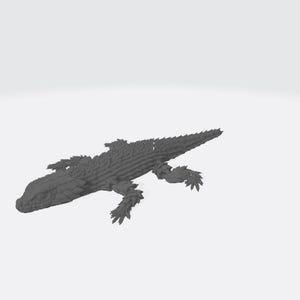 May include: A dark gray, three-dimensional printed figurine of a lizard with a textured, scaly surface. The reptile is depicted in a crawling position with four legs extended outward and a long, pointed tail extending behind its body.