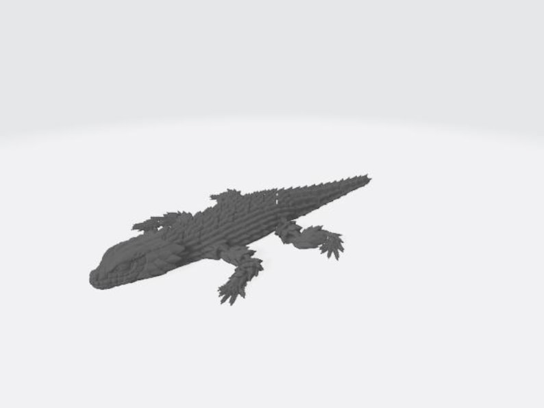 May include: A dark gray, three-dimensional printed figurine of a lizard with a textured, scaly surface. The reptile is depicted in a crawling position with four legs extended outward and a long, pointed tail extending behind its body.