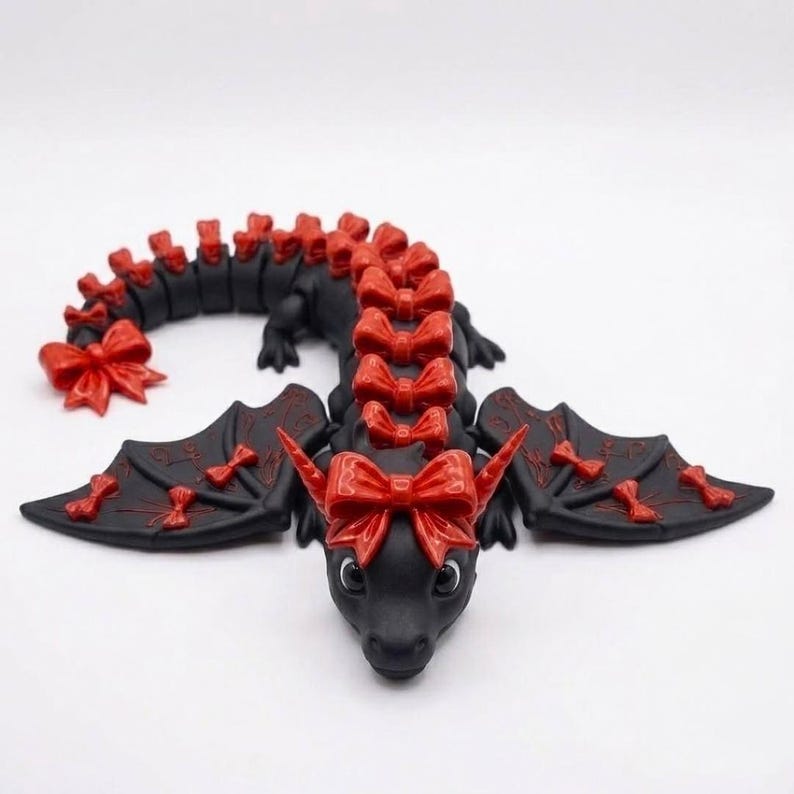 Front view of an articulated Bow Dragon 3D printable model showing an adorable face, oversized head bow, engraved wings, and fully articulated body.