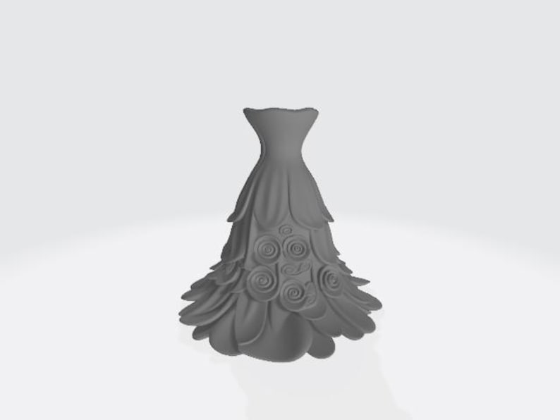 Puede incluir: Un jarr&oacute;n decorativo gris, estilizado en forma de vestido. Presenta detalles en capas con forma de p&eacute;talos y adornos con forma de rosas. El dise&ntilde;o es sim&eacute;trico y se encuentra sobre un fondo blanco liso.