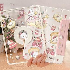 Könnte beinhalten: Transparente Tablet-Hülle mit einem weißen und rosa Design mit Hello Kitty-Charakteren, Kuchen und Donuts. Die Hülle hat einen eingebauten Ständer und einen rosa Stifthalter. Der Text "CuteXCaseDesign" befindet sich unten.