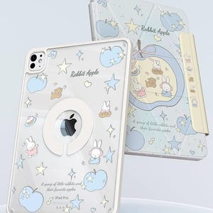 Puede incluir: Una funda y una cubierta para iPad Pro con un dise&ntilde;o caprichoso. La funda transparente presenta el texto "Rabbit Apple" e ilustraciones de conejos, manzanas, estrellas y notas musicales. La cubierta tiene un dise&ntilde;o a juego y un cierre magn&eacute;tico.