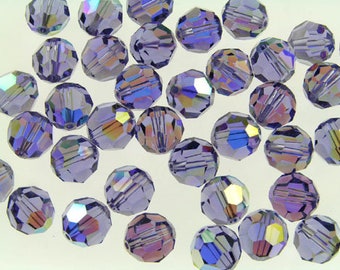 May include: A collection of faceted, iridescent beads in shades of lavender and purple. The beads have a multi-faceted design that reflects light, creating a shimmering effect. These beads are suitable for jewelry making and craft projects.