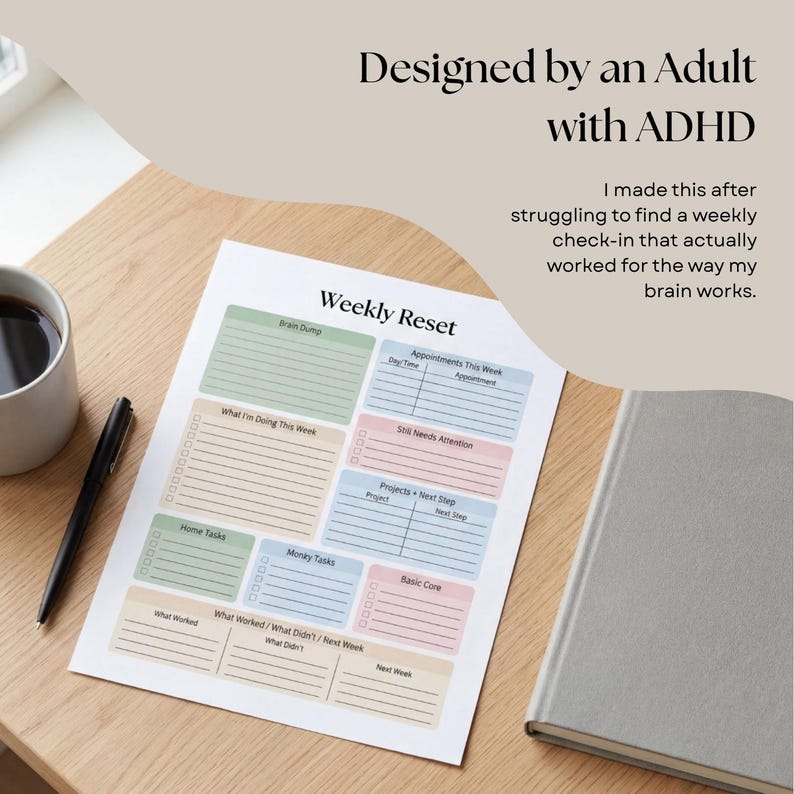 Pode incluir: Um planejador de reinicializa&ccedil;&atilde;o semanal com se&ccedil;&otilde;es em cores pastel para tarefas e compromissos. O texto "Designed by an Adult with ADHD" est&aacute; no topo. Uma x&iacute;cara de caf&eacute;, caneta e caderno tamb&eacute;m est&atilde;o na superf&iacute;cie de madeira.