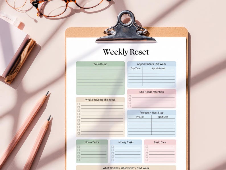Pode incluir: Uma prancheta com uma folha de planejamento "Weekly Reset". A folha tem se&ccedil;&otilde;es para "Brain Dump", "Appointments", "What I'm Doing This Week", "Home Tasks", "Money Tasks" e "Basic Care". Dois l&aacute;pis e &oacute;culos s&atilde;o vis&iacute;veis.
