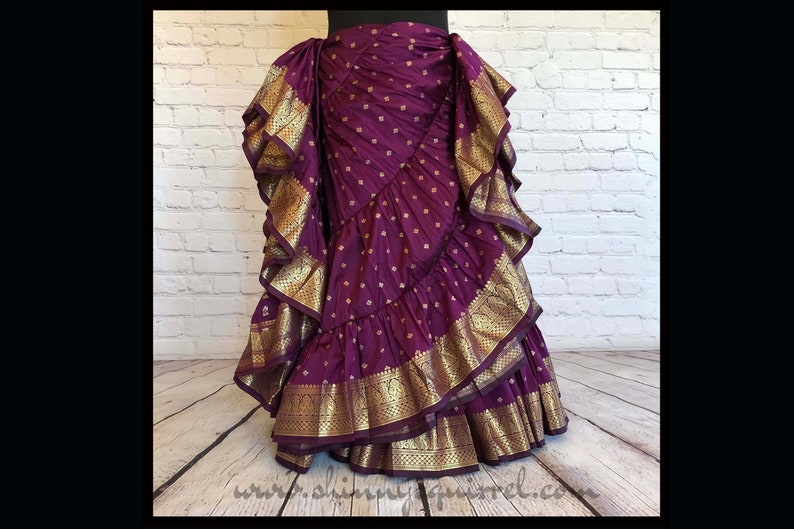 May include: A purple skirt with gold trim and a layered, ruffled design. The skirt is made of a soft, flowing fabric and has a unique, bohemian style.